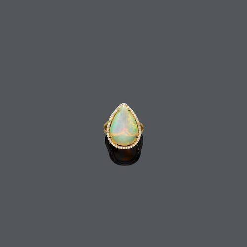 OPAL DIAMOND RING. Yellow gold 750. Set with 1 pear-shaped crystal-opal of ca. 12.20 ct, within a diamond surround, weighing ca. 0.60 ct. Size ca. 55.