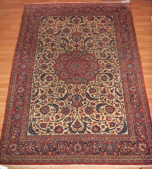 ISFAHAN old.White ground with a red central medallion, finely patterned with trailing flowers and palmettes, red border, slight wear, 240x150 cm.