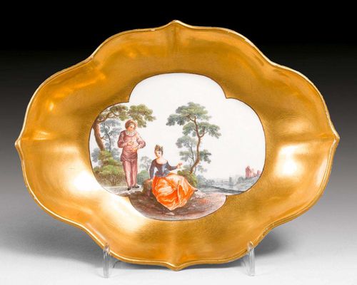 QUATREFOIL-SHAPED SOUCOUPE WITH WATTEAU SCENE, Meissen, circa 1745.The outer side of the wall edged with a gold border. Underglaze blue sword mark. D 17cm.