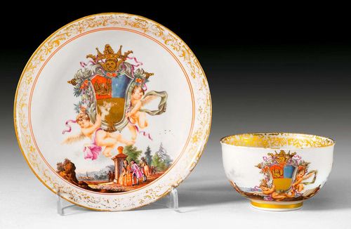 CUP AND SAUCER WITH THE FOSCARI COAT OF ARMS, Meissen, circa 1735-40.Each piece decorated with a crowned coat of arms of the Venetian Foscari family carried by two hovering putti. Underglaze blue sword marks, potter's mark oo in base ring of saucer, / and four quadrants in base ring of cup, three dots as gold mark. Gilding slightly rubbed. The painting of the coat of arms on the cup slightly retouched.