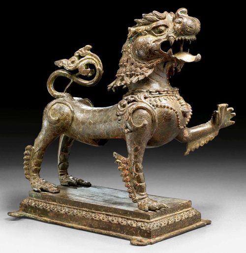 BRONZE LION.Nepal, ca. 17th century  H 25 cm. With traces of gilding and red ceremonial powder. The plinth with inscription.