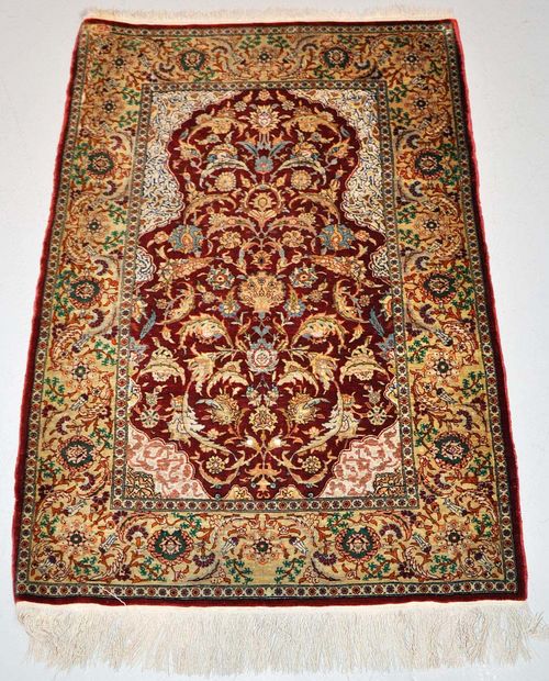 HEREKE SILK.Red mihrab with light spandrels, patterned with trailing flowers and palmettes, beige border, slight wear, 80x120 cm.