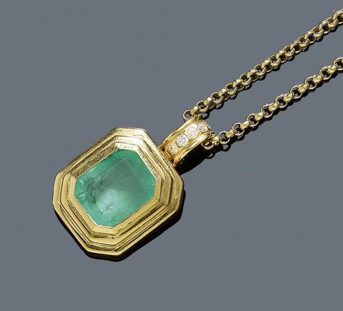 EMERALD AND DIAMOND PENDANT. Yellow gold 750. Casual-elegant pendant, set with 1 light step-cut emerald of ca. 7.00 ct, small chip on the edge, in a broad setting. The clip eyelet is additionally decorated with 6 brilliant-cut diamonds weighing ca. 0.12 ct. Matching belcher chain in yellow gold 585, L ca. 82 cm.