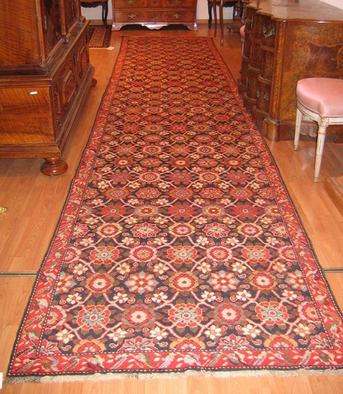 KARABACH runner old.Blue central field, patterned throughout with colourful blossoms, red border, good condition, 560x115 cm.