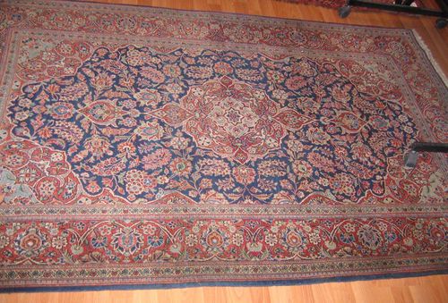 KESHAN old.Blue ground with a red central medallion and corner motifs, the entire carpet is florally patterned, red border, good condition, 135x215 cm.