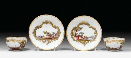 PAIR OF CUPS AND SAUCERS WITH LANDSCAPE SCENES, Meissen, circa 1745.Each piece with a figural landscape scene in a gold lattice cartouche edged in black. Underglaze blue sword marks, gold numbers 4. Minor rubbing.