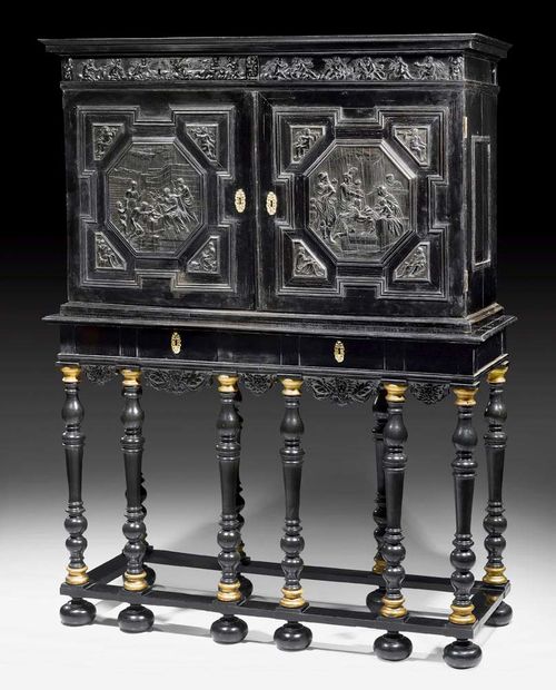 IMPORTANT CABINET,Renaissance, Flemish circa 1650. Ebonised pearwood, finely carved with scenes from the New Testament, also with putti playing music and a frieze. The cabinet with salient cornice, baluster legs, two doors at the front and drawers. The fitted interior with large central double door, surrounded by 10 drawers of different sizes. Also marquetry decoration and 7 small drawers. With bronze and brass knobs. 154x58x199 cm. Provenance: from a European collection.