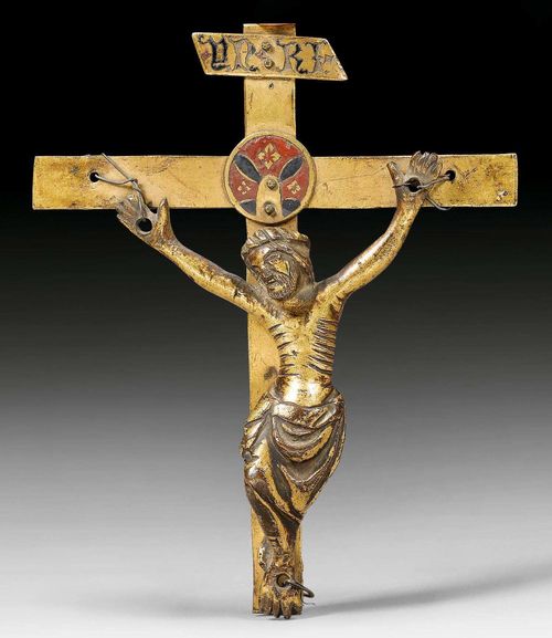 CRUCIFIX,probably Italy, circa 1300. Gilt bronze. The center with champleve plaque as nimbus and a plaque at the top with the inscription INRI. Cross and body do not belong together. H 15, W 12 cm. Body attached with wire.
