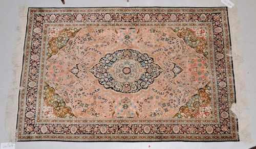 CHINA SILK.Pink central field with a blue central medallion and green corner motifs, the entire carpet is finely patterned with trailing flowers, black border, good condition, 125x185 cm.