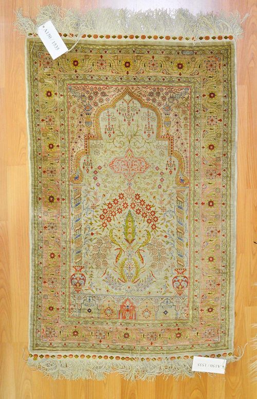 HEREKE SILK, PRAYER.Grey mihrab with pink spandrels. The entire carpet is finely patterned with floral motifs in delicate pastel colours. Pink border. Slight wear, 73x110 cm.