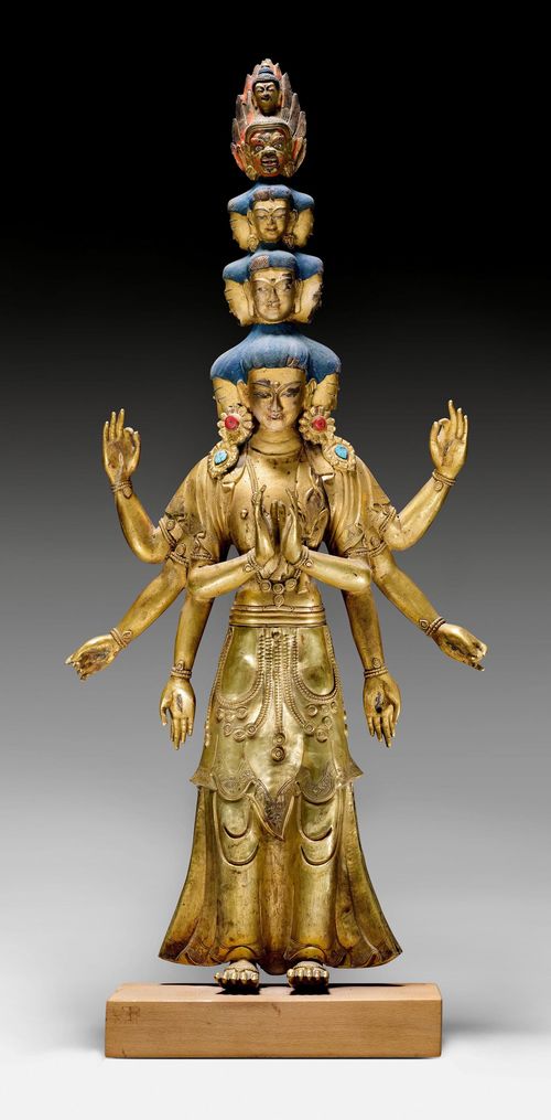 A GILT COPPER STANDING AVALOKITESHVARA WITH ELEVEN HEADS AND EIGHT ARMS. Tibet, 18th c. Height 58.5 cm. Lower half in repoussé.