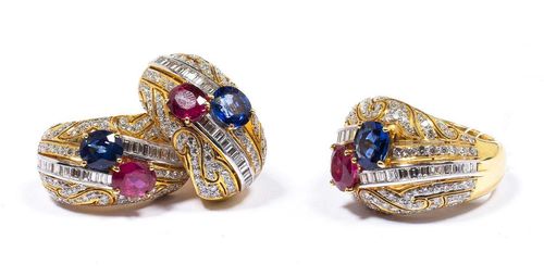 RUBY, SAPPHIRE AND DIAMOND RING AND EAR CLIPS. Yellow gold 750. Attractive set, comprising a cocktail ring, the convex top of floral open-work design, set with a ruby and a sapphire, set throughout with 2 lines of baguette-cut diamonds and numerous brilliant-cut diamonds. Size 56. Correspondingly worked, broad half-creole ear clips, each set with a ruby and a sapphire, numerous baguette-cut diamonds and brilliant-cut diamonds. Total weight of the rubies ca. 3.60 ct, total weight of the sapphires ca. 3.15 ct and total diamond weight ca. 4.25 ct.