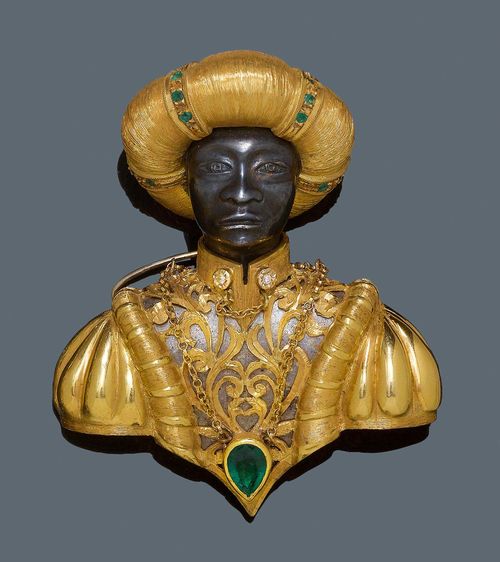 PEARL, EMERALD AND DIAMOND BROOCH, ca. 1980. Yellow gold and silver, 71g. Fancy, large Moretto brooch, the turban decorated with a Mabe pearl and numerous small emeralds. The collar decorated with 2 brilliant-cut diamonds, weighing ca. 0.03 ct, as buttons. The pendant set with an emerald of ca. 1.00 ct. The head in blackened silver. Maestri Orafi. Ca. 6.3 x 5.4 cm. With case and jewellery certificate by Guiseppe Cosentino.