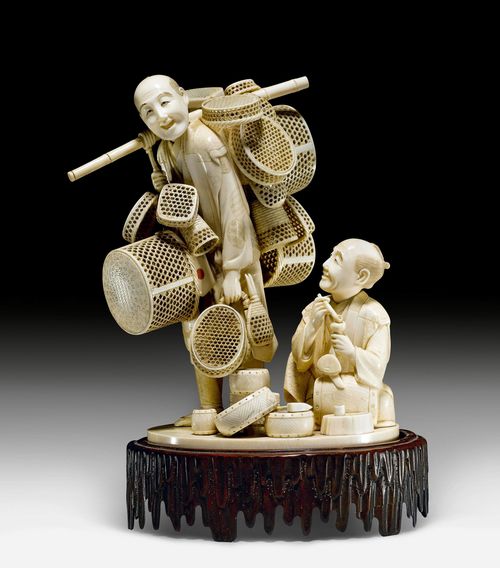 A FINE IVORY OKIMONO OF A DRUM MAKER AND A BASKET SELLER. Japan, Meiji period, height 29 cm (incl. wood base).