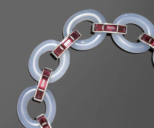 CHALCEDONY AND TOURMALINE BRACELET. White gold 750. Decorative bracelet of 9 light-blue oval chalcedony rings, interconnected by intermediary bars, each set with 3 crimson baguette-cut tourmalines totalling ca. 6.50 ct. L ca. 20 cm.