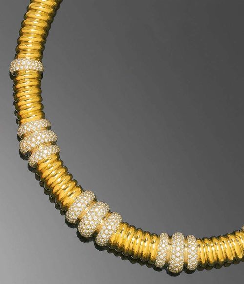 GOLD AND BRILLIANT-CUT DIAMOND NECKLACE. Yellow gold 750, 120g. Casual-elegant "tube de gaz" necklace, the front decorated with 11 ring motifs, entirely set with numerous brilliant-cut diamonds totalling ca. 5.90 ct and of fine quality. L ca. 43 cm.