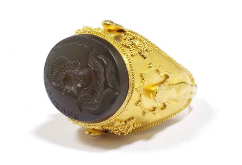 AGATE AND GOLD RING, ca. 1940. Yellow gold 916. Stylish mantle ring in Persian style, set with an agate engraved with a portrait of a Sassanid, the edge inscribed. The shoulders adorned with feminine figures and pseudogranulation. Size ca. 56.