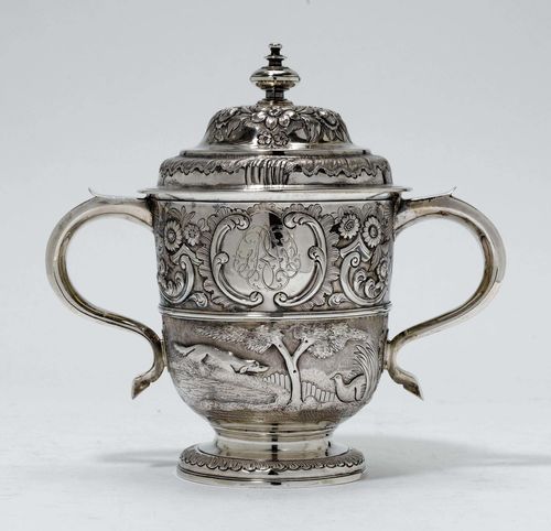 GOBLET AND COVER,London 1733/34. Maker's mark: Richard Bayley. Chased and chiselled. Urn-shaped body with dog chasing pheasants, in relief. Above: blossoms, volute decoration with cartouche and engraved initials. Goblet matches cover. H 23 cm, 900g.