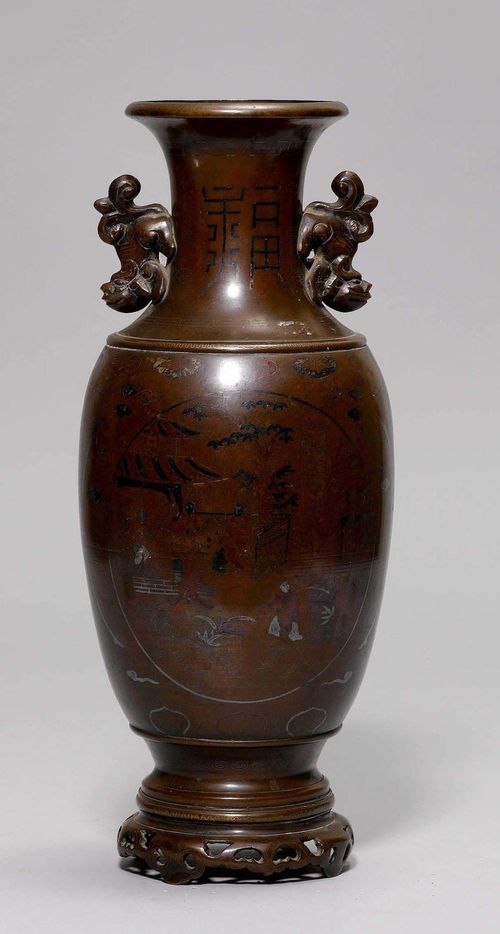 VASE.China/Vietnam, 19th c. H 39 cm. Bronze inlaid with metal. Ovoid vase with wide neck and flared rim, having two lion handles. On the vessel body two medallions with figures in a garden setting. On an openwork base.