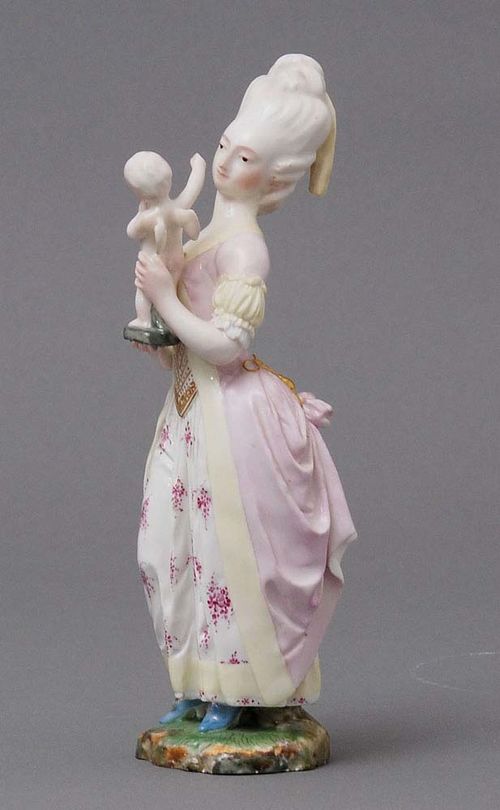 STATUETTE OF YOUNG LADY WITH CUPID, Hoechst, late 18th century.Model by J. Melchior, Rococo lady with powdered wig and pastel-colored dress gazing at a putto in her hands, on flat grass base. Underglaze blue wheel mark, incised mark NZ 10 HM. H 18cm. Restored.