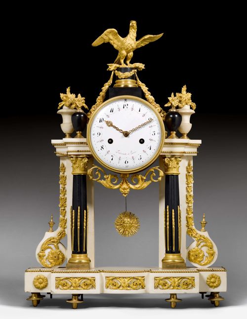 PORTAL CLOCK, Louis XVI, the dial signed FAISANT A PARIS. White and black marble and bronze. Cylindrical case decorated with an eagle on top, the front with fluted columns and the rear with rectangular pillars, the sides with volutes. Decorative friezes and garlands in bronze. White enamel dial painted with a flower garland. Parisian movement striking the ½-hour on bell. H 60 cm.
