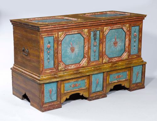 PAINTED CHEST, Bavaria, dated 1785. Pine, partly marbled, painted with blue reserves, painted with flaming hearts and flowers and carved with rocailles. Rectangular body with folding cover. The cover and the front, recessed. Iron mounts. 154x66x92 cm. 1 key.