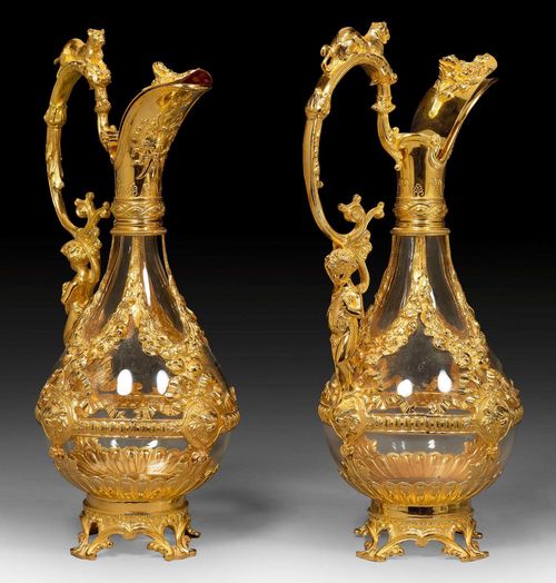 PAIR OF GLASS CARAFFES MOUNTED IN VERMEIL. France, 19th century. With maker's mark. Restoration. Transparent glass insert. H 33 cm.