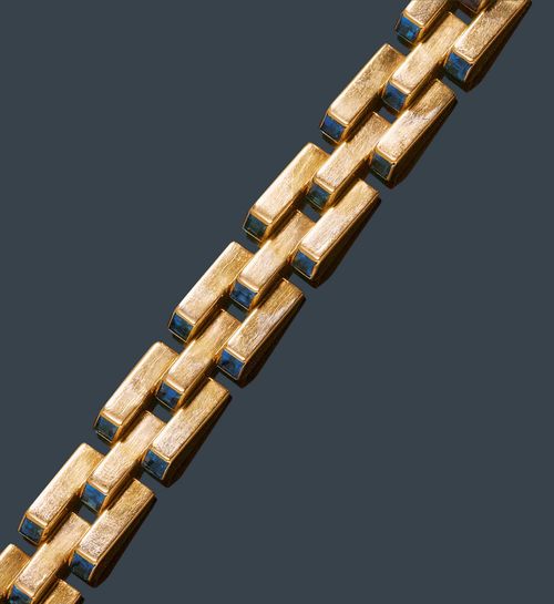 GOLD AND SAPPHIRE BRACELET, TIFFANY CO., New York, ca. 1940. Yellow gold 585. Attractive, casual-elegant bracelet of fantasy brick-patterned links, each decorated with a square-cut sapphire. 33 sapphires in total, weighing ca. 6.60 ct. L ca. 18.2 cm. With copy of insurance estimate.