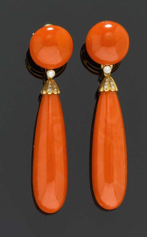 CORAL AND BRILLIANT-CUT DIAMOND PENDANT EARRINGS. Yellow gold 750. Decorative clip earrings/stud earrings, each of 1 long, drop-shaped red coral of 50 x 14.5 mm on a movable mount below 1 coral button of 17.9 mm Ø and additionally decorated with 14 brilliant-cut diamonds totalling ca. 0.20 ct. L ca. 7.7 mm.