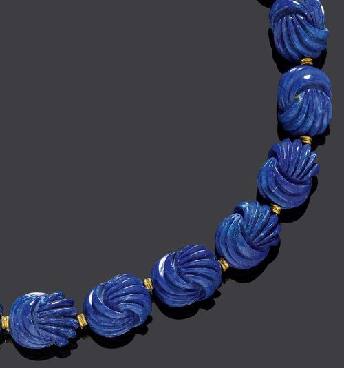 LAPIS-LAZULI AND GOLD NECKLACE. Yellow gold 750. Very attractive, casual necklace of 20 egg-shaped lapis-lazuli, cut with a knot motif, of ca. 19 x 15 mm. Matching gold fastener and 20 gold rondelles as intermediary links. L 47 cm.