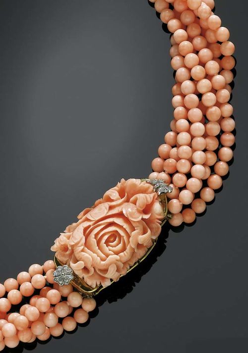 CORAL AND DIAMOND NECKLACE/TORSADE. Yellow gold 750. Elegant, seven-row necklace of light pink coral beads of 5 mm Ø, fastener consists of 1 large, peony-shaped cut coral, flanked by a small butterfly and a shamrock, set with diamonds totalling ca. 0.20 ct. L ca. 44 cm.