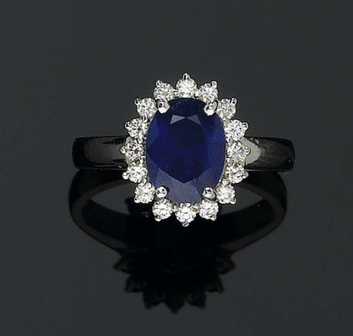 SAPPHIRE AND DIAMOND RING. White gold 585. Classic ring, the top set with 1 oval Burma sapphire of 2.03 ct in a brilliant-cut diamond surround of ca. 0.23 ct. Size 52. GRS Report No. GRS2006-122295.