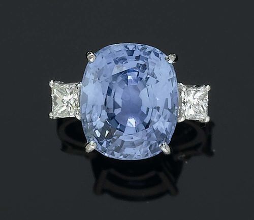 SAPPHIRE AND DIAMOND RING. White gold 750. Classic-modern ring, the top set with 1 antique oval light-blue Burma sapphire of 13.57 ct, not heat-treated, flanked by 2 princess-cut diamonds totalling ca. 0.60 ct. Size 52. GRS Report No. GRS2006-122293.