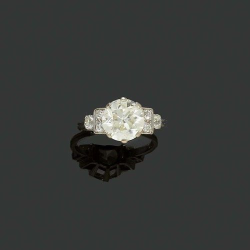 DIAMOND RING, ca. 1930. Platinum and white gold. Decorative solitaire model, the top set with 1 old-mine-cut diamond of ca. 3.90 ct, ca. M-N/VS2, flanked by 6 old-mine-cut diamonds totalling ca. 0.50 ct. Size 61.