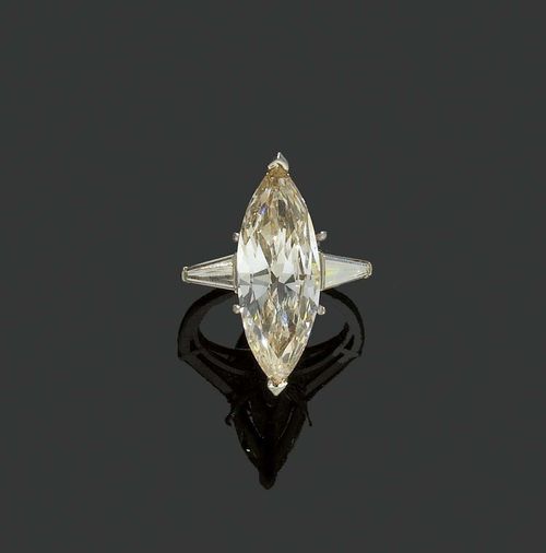 DIAMOND RING, ca. 1950. Platinum, 10% iridium. Classic-elegant solitaire model, the top set with 1 navette-cut diamond of 6.5 ct, tinted, light pinkish-brown , N-O/SI2, flanked by two trapeze cut diamonds totalling ca. 0.50 ct. Numbered 7677. Size 51. With Gemlab Report No. 1743/08.